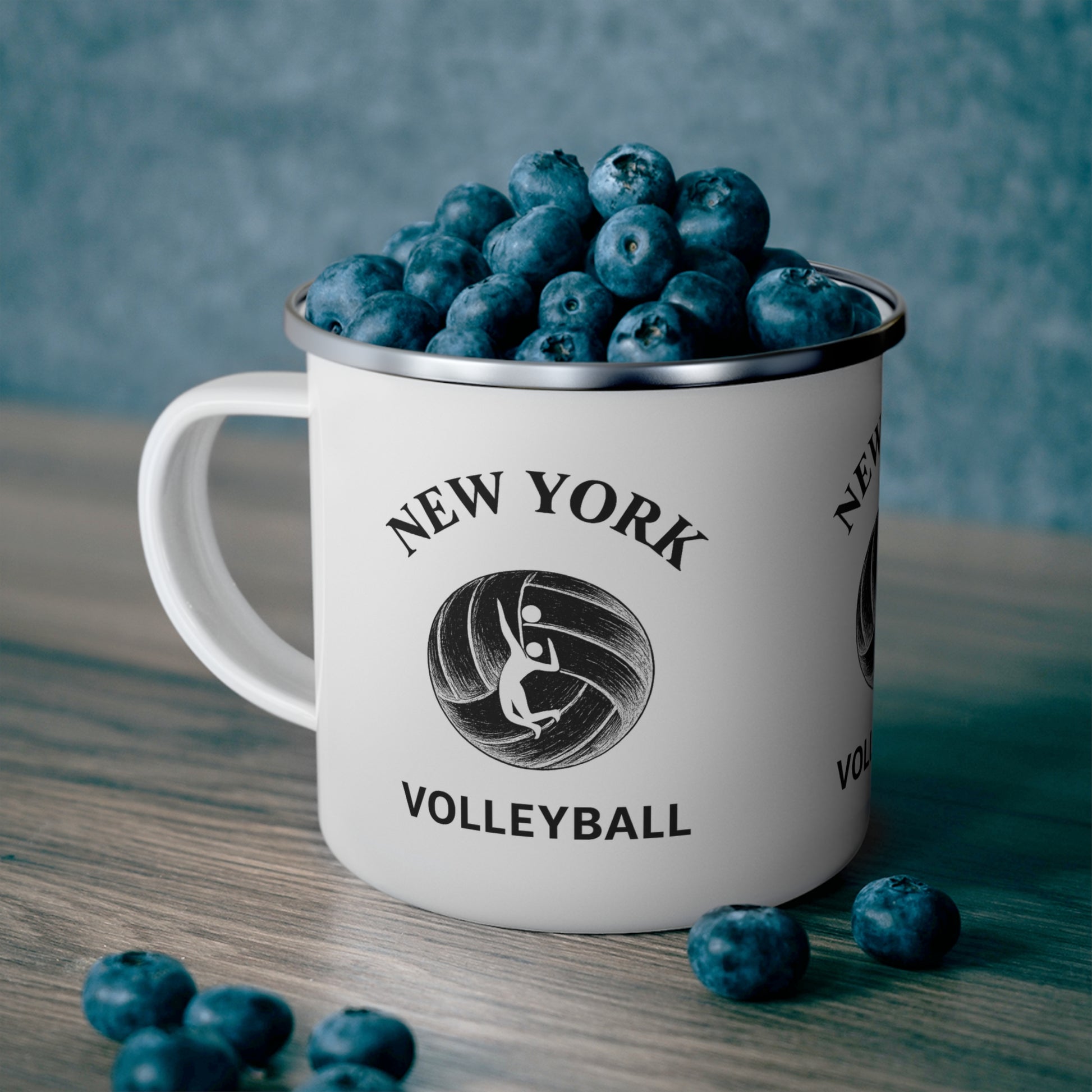White enamel volleyball mug with black rim and city-style print