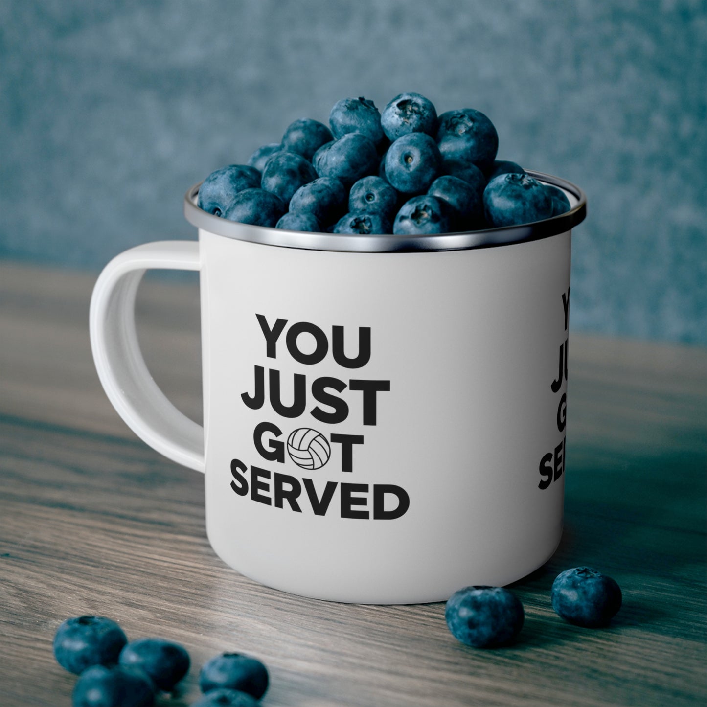 Volleyball players holding enamel mugs after a beach match.